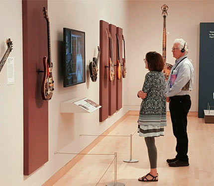 Visitors in front of video and guitar display
